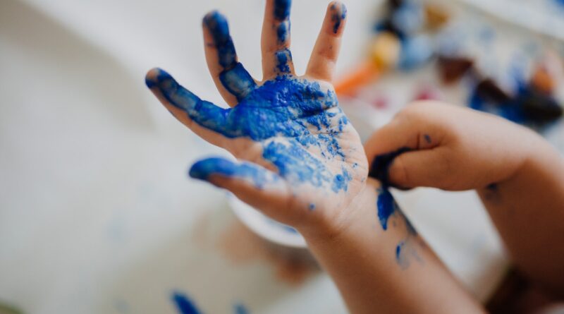 person with blue paint on hand
