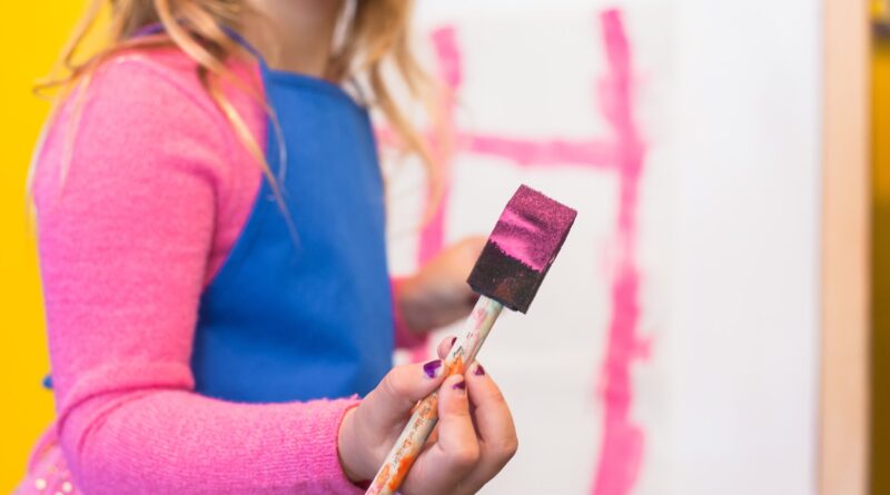 girl using pink paint brush