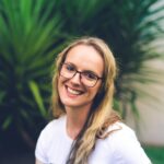 woman wearing white crew-neck shirt near green leaf plant